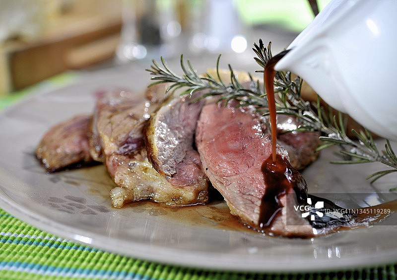 烤羊肉配肉汁和迷迭香图片素材