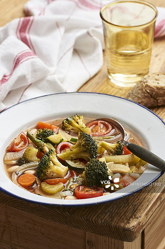 乡村木桌上的搪瓷盘蔬菜杂烩汤图片素材