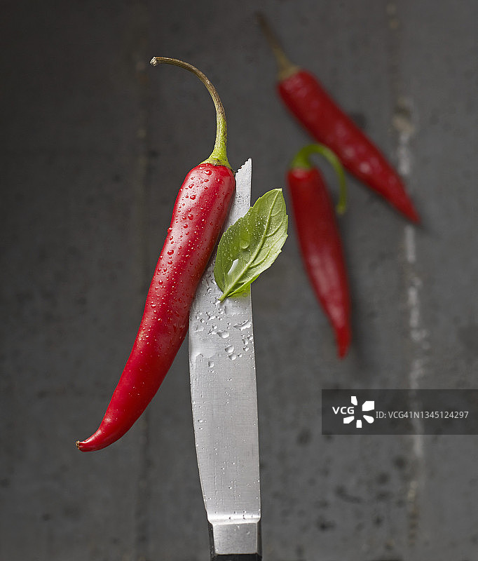 刀尖上的红色辣椒和罗勒与水滴图片素材