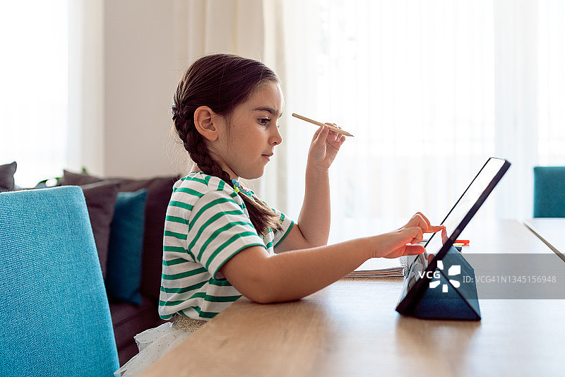 小女孩在客厅上网课图片素材