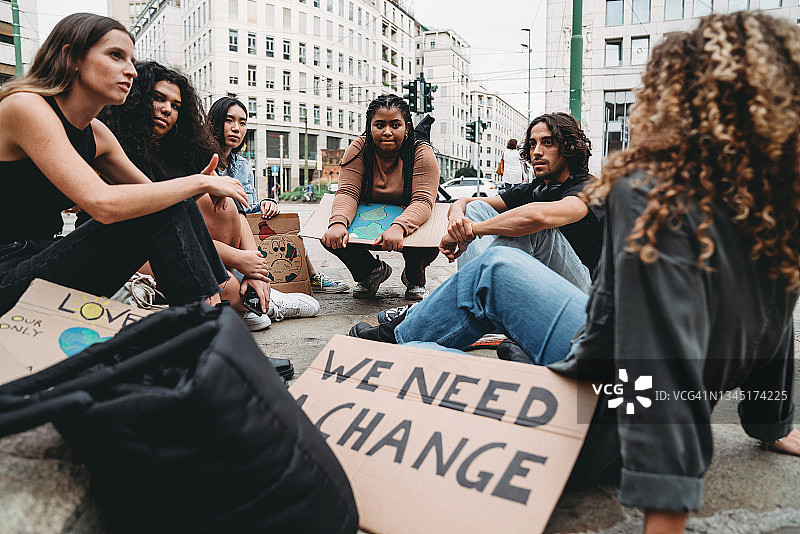 一群年轻人在城市气候变化示威后休息图片素材