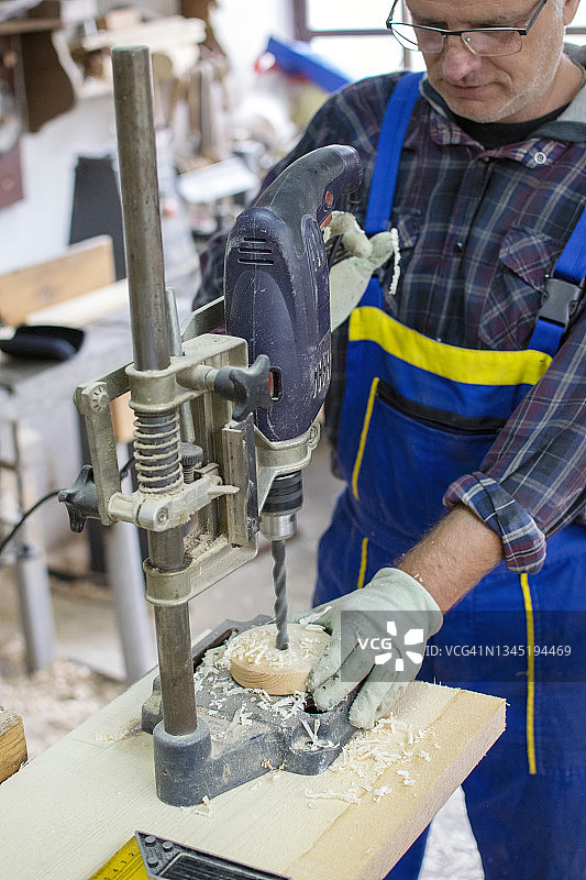 木匠在工作室使用钻床图片素材