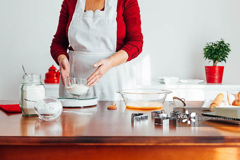 女人在厨房用秤测量面粉图片素材