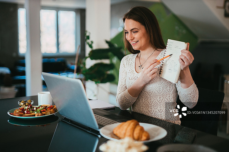在家工作，在视频通话中解释她写了什么的女人图片素材