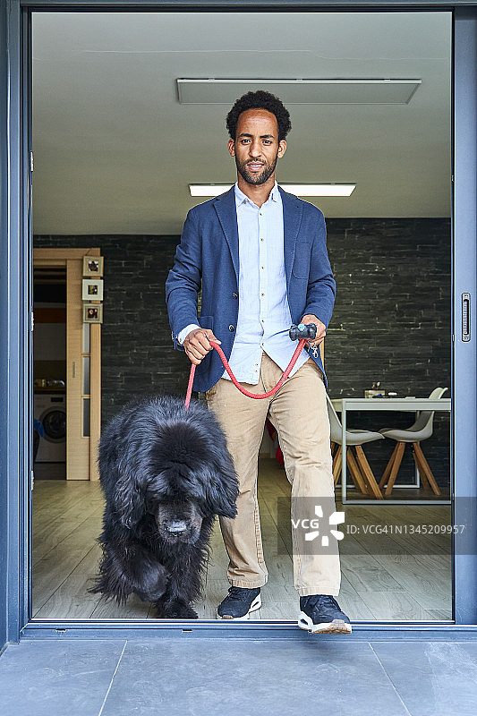 年轻的非洲裔美国男人在街区遛狗图片素材