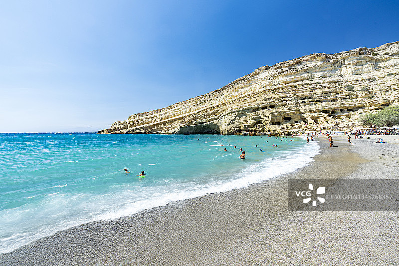 克里特岛马塔拉海滩，畅游于清澈海水中的泳客图片素材