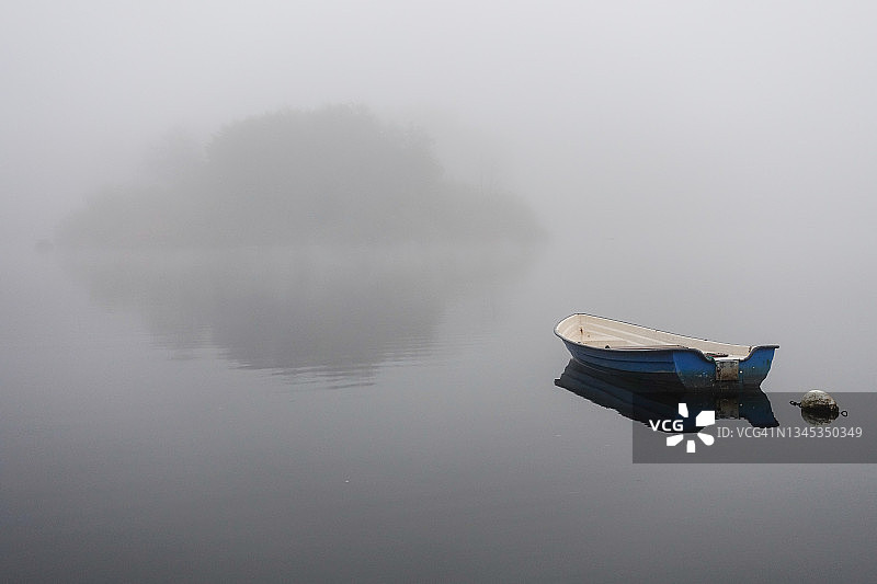 秋季雾中湖面上带岛屿的游船图片素材