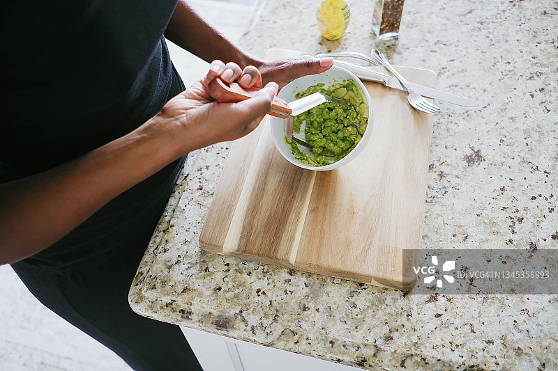 女人在碗里捣碎鳄梨图片素材