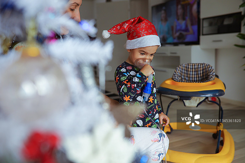 幼儿拿着吸入面罩，母亲在一旁观察图片素材