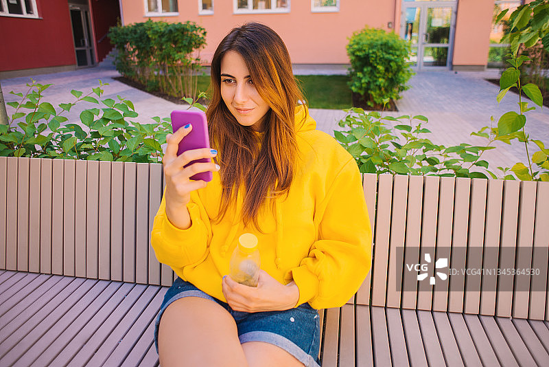 城市女性在彩色建筑背景下自拍图片素材