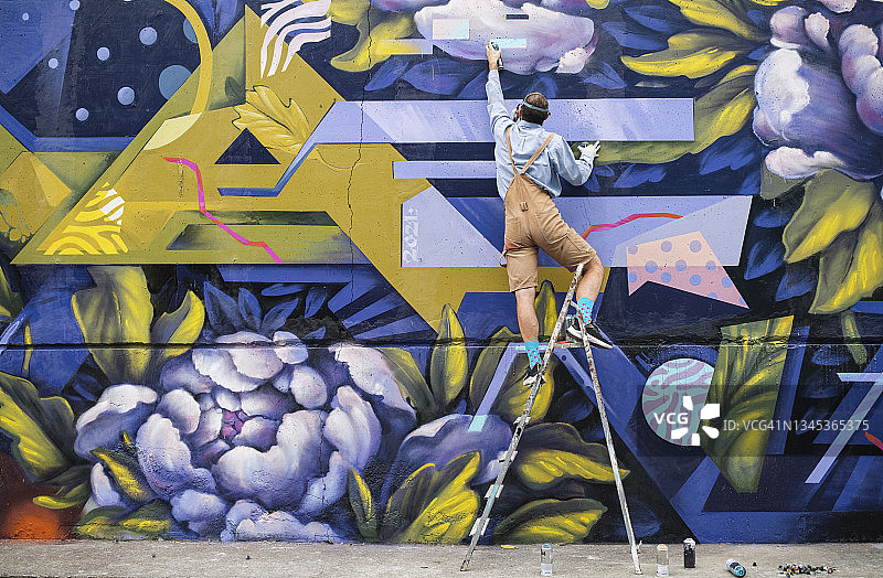 在梯子上墙绘的街头艺术家图片素材