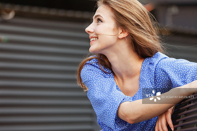 户外肖像：迷人的19岁长发女子，身穿蓝色夏装图片素材