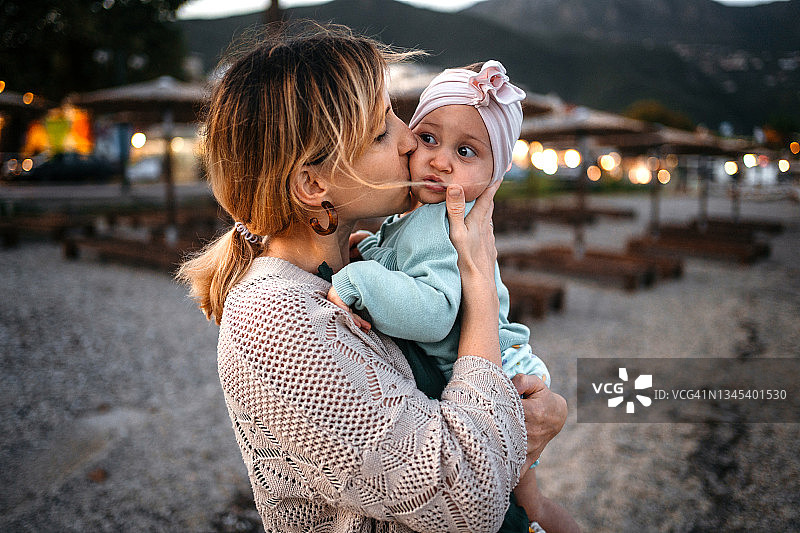 温柔的亲吻：母亲亲吻她的女儿图片素材