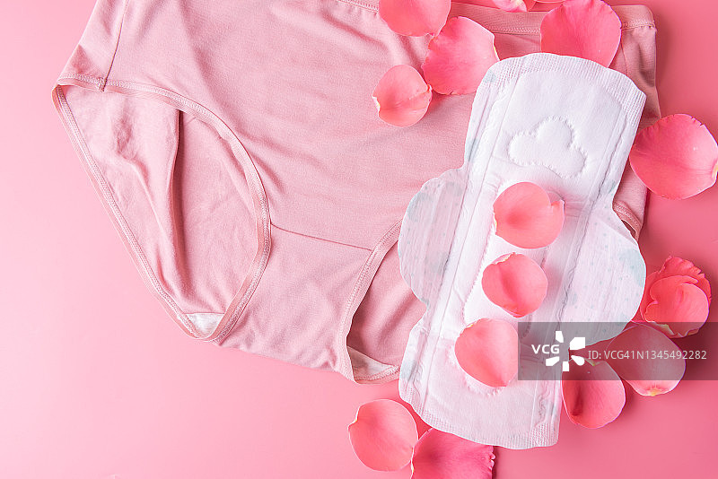 粉色背景上的女士内裤和卫生巾，女性卫生健康概念图片素材
