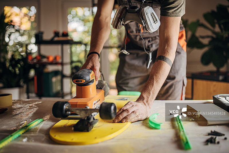 青年男子打磨滑板图片素材