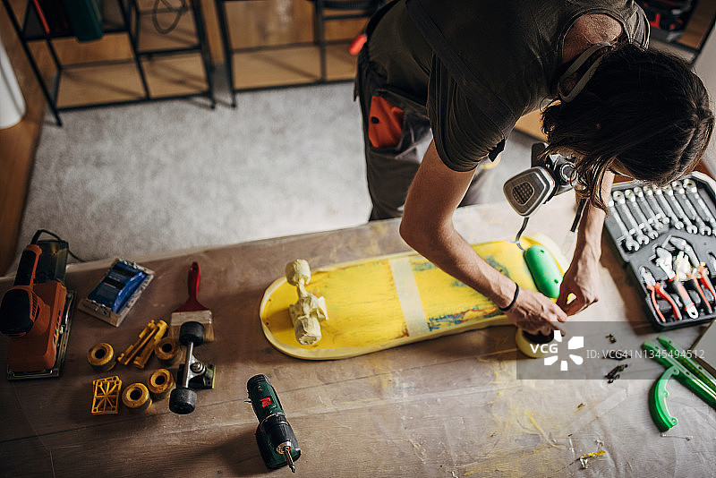 男人准备给滑板上漆图片素材