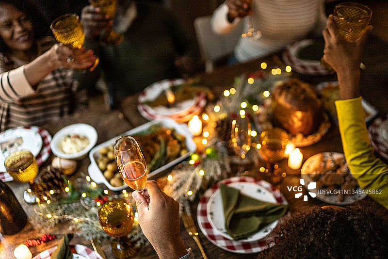 在家享用圣诞晚餐时家庭祝酒图片素材