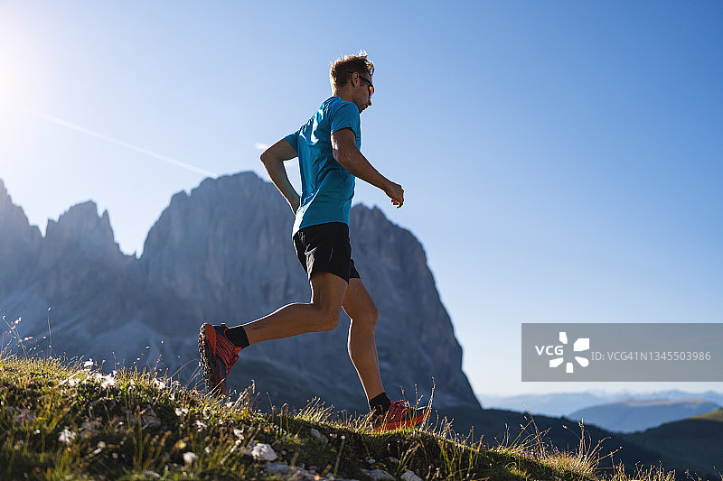 年轻男人在多洛米蒂山脉上进行越野跑图片素材