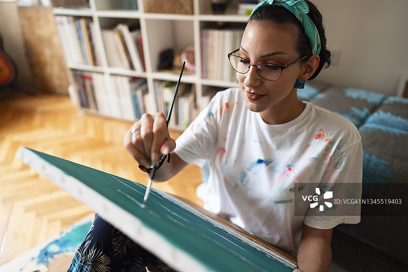 正在画布上绘画的 gifted 女艺术家享受创作时光图片素材