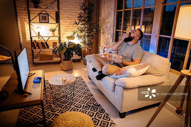 男人看电视吃爆米花图片素材