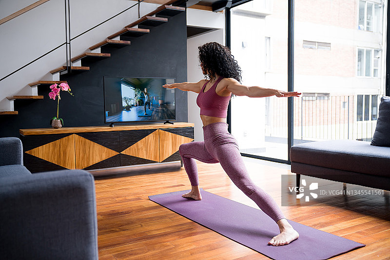 在家中参加健身课程的运动型女人图片素材