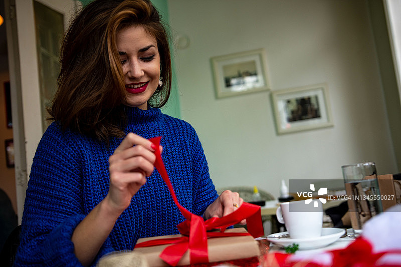 年轻女人准备圣诞节，包装手工礼品盒图片素材
