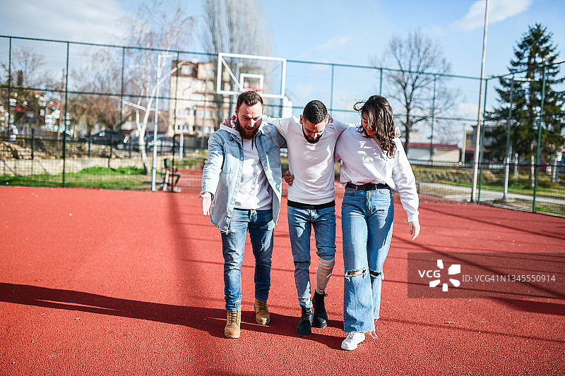 男女帮助受伤的朋友从腿伤中恢复图片素材