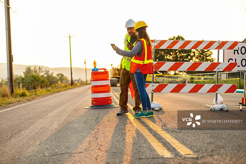 西班牙裔工人在道路施工现场使用平板电脑进行通讯图片素材