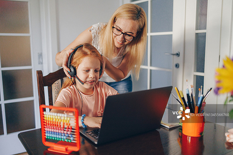 母亲帮助女儿准备网课或家庭作业图片素材