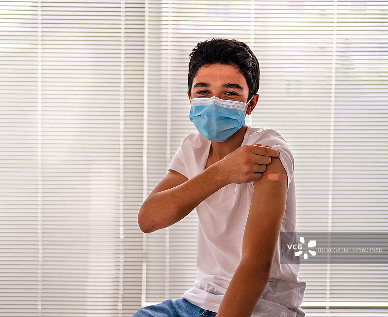 接种疫苗后展示肩膀的男孩图片素材