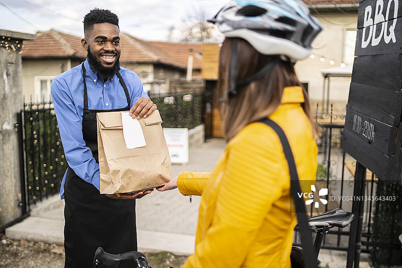 在路边自提区向骑自行车的女性提供路边自提食品图片素材