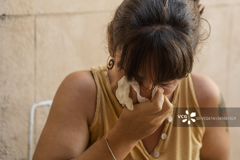 用纸巾擦鼻涕的年轻女人图片素材