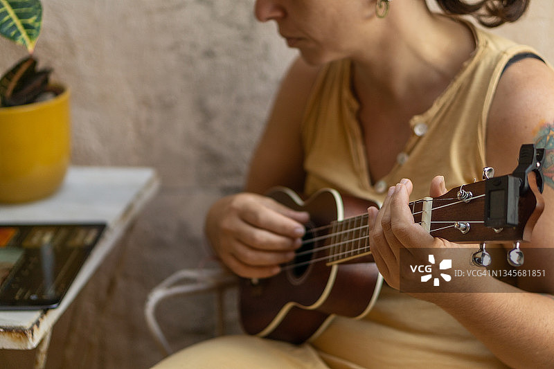 30多岁的女人喜欢用夏威夷尤克里里弹奏音乐图片素材