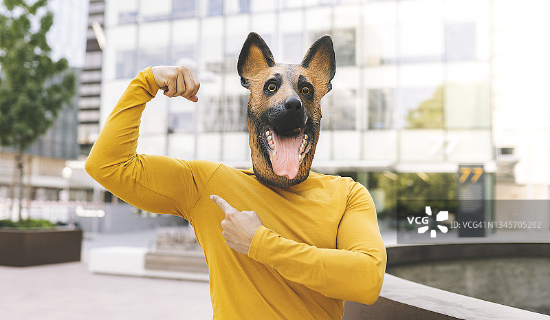 戴着狗头面具的男人在城市里展示肌肉图片素材