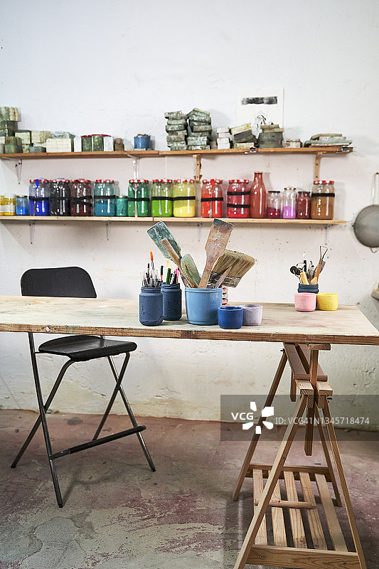 混凝土车间货架上排列的彩色容器图片素材