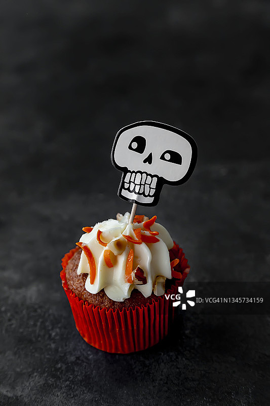 黑色背景下的装饰纸杯蛋糕特写：万圣节庆祝概念图片素材