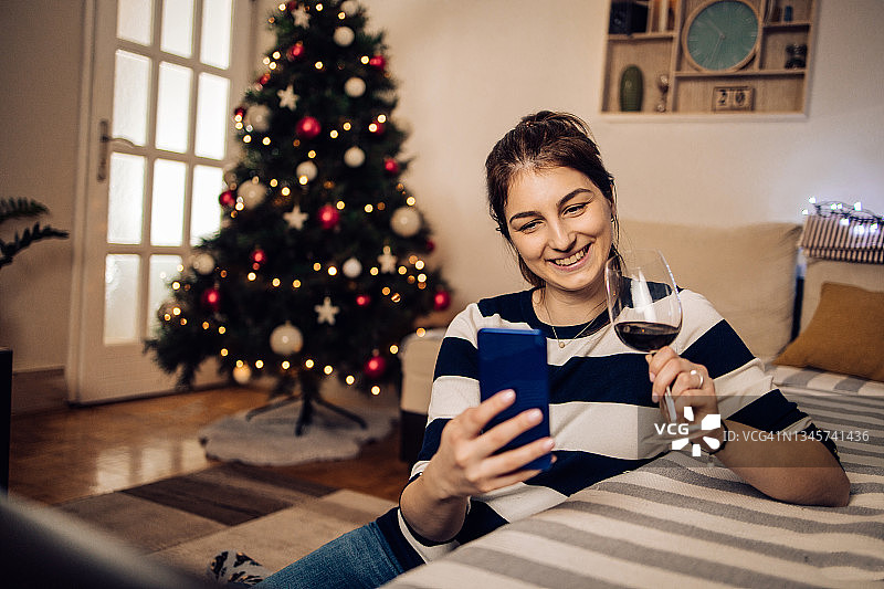 在圣诞前夜与线上约会对象碰杯的女孩图片素材
