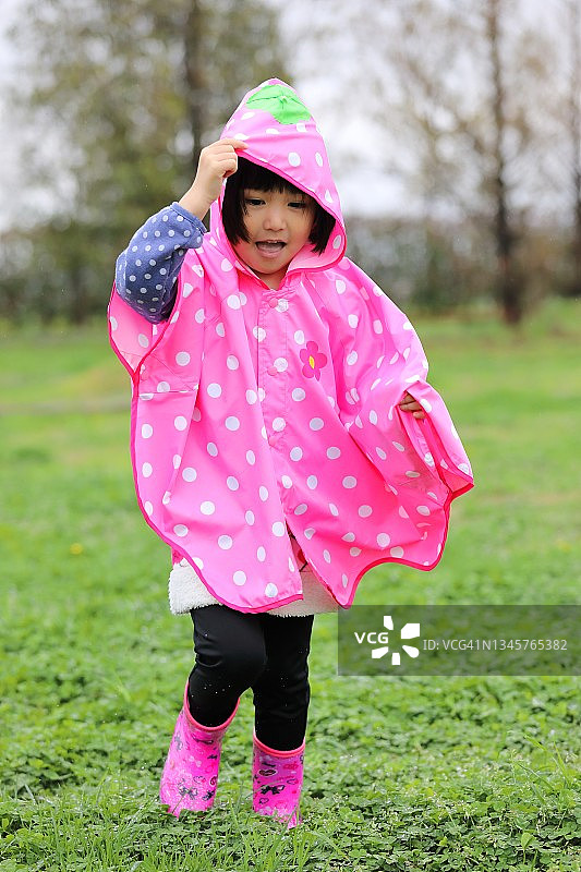 小孩子在雨天里高兴地在公园散步图片素材