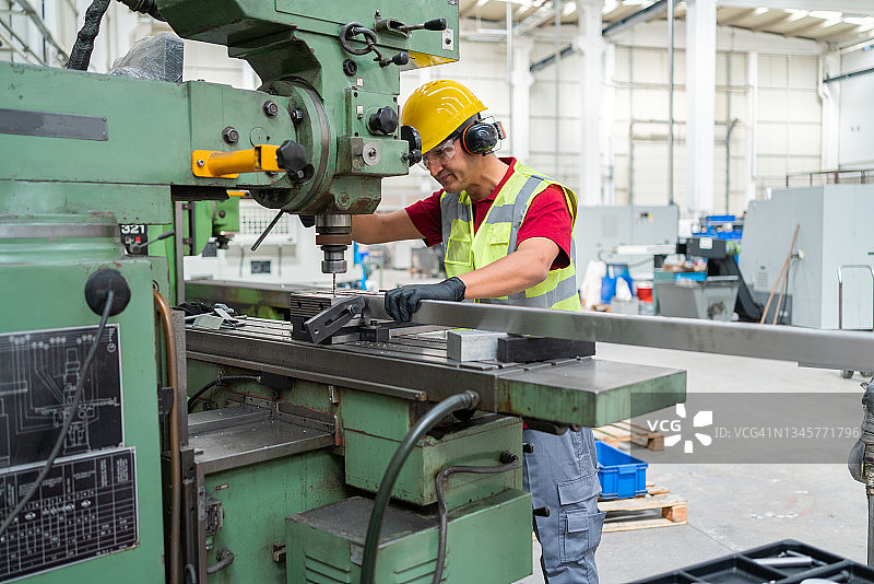 工厂工人操作金属机器图片素材
