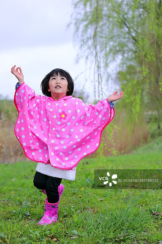 在雨中跳舞并抬头看的儿童图片素材