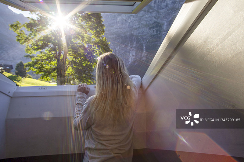 女人在家里的窗台上放松地向外看图片素材