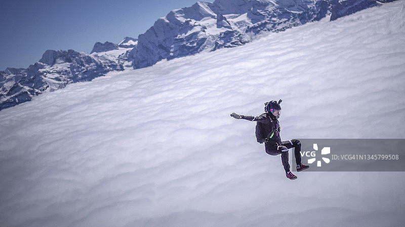 在云层之上的晴空中跳伞的女跳伞运动员图片素材