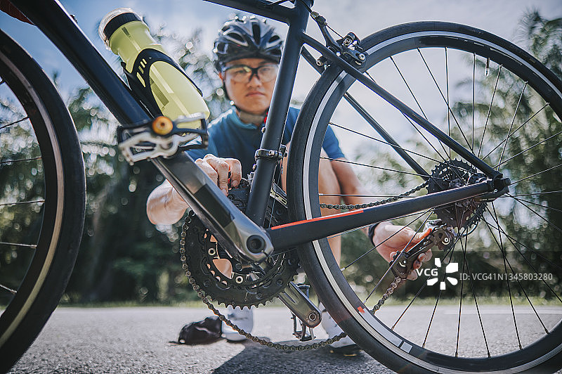 中国自行车手在乡村路边修理自行车链条图片素材
