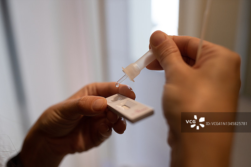 女子在家进行新冠抗原自测特写图片素材