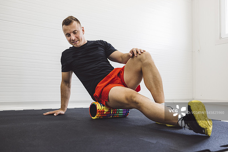 健壮男士用泡沫轴放松肌肉图片素材