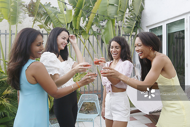 一群混血女性在户外露台上休闲的庆祝活动中举杯庆祝图片素材