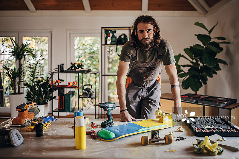 在工作室修理滑板的男人图片素材