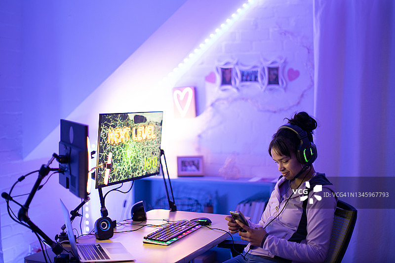 青少年女性玩家在晚上使用智能手机图片素材