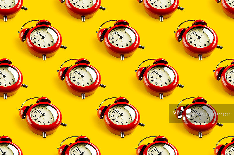 明黄色背景上的红色复古闹钟，时间流逝概念无缝图案图片素材