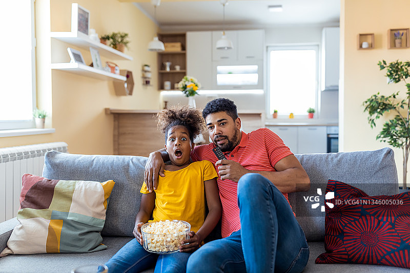 父女在家看恐怖片吃爆米花图片素材